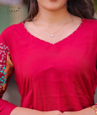 Close-up of threadwork on red kurti