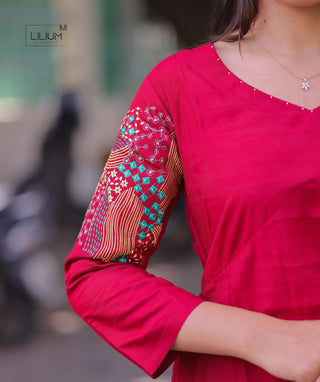 Close-up of threadwork on red kurti