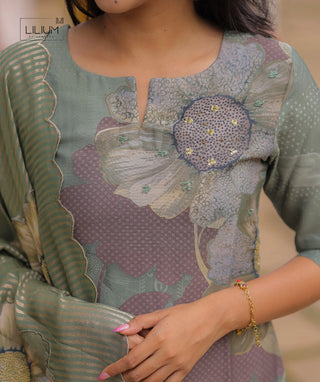 Close-up of sequin floral embroidery on green kurti fabric